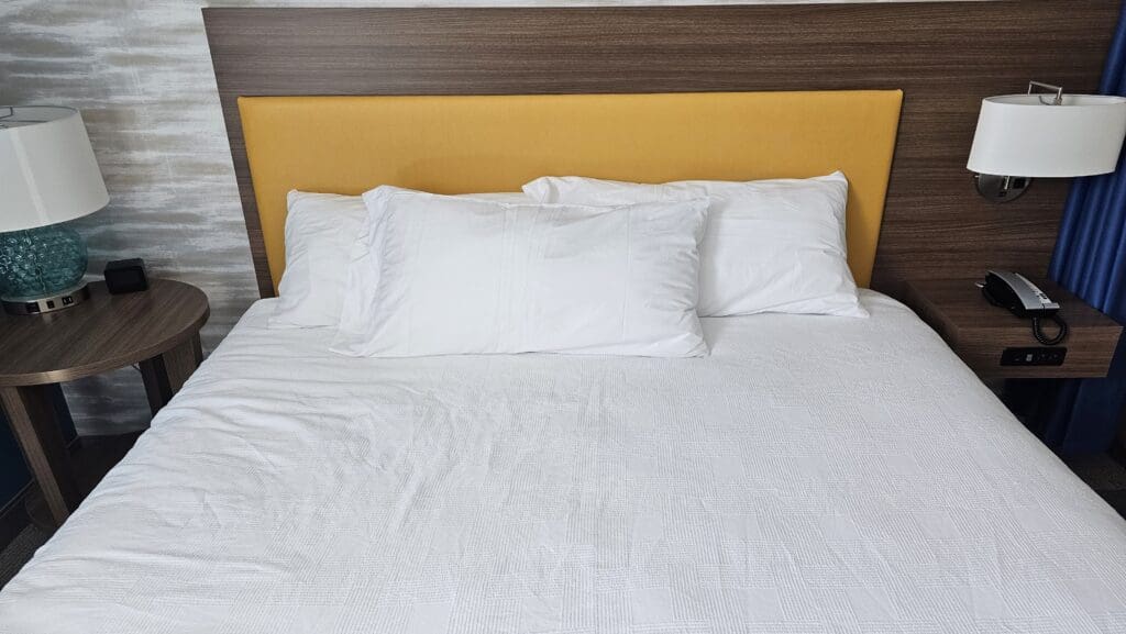 a bed with white pillows and a yellow headboard