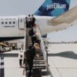 people walking up the stairs of an airplane