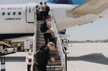 people walking up the stairs of an airplane