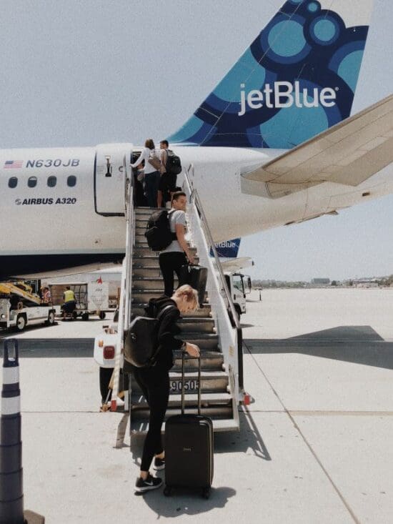 people walking up the stairs of an airplane