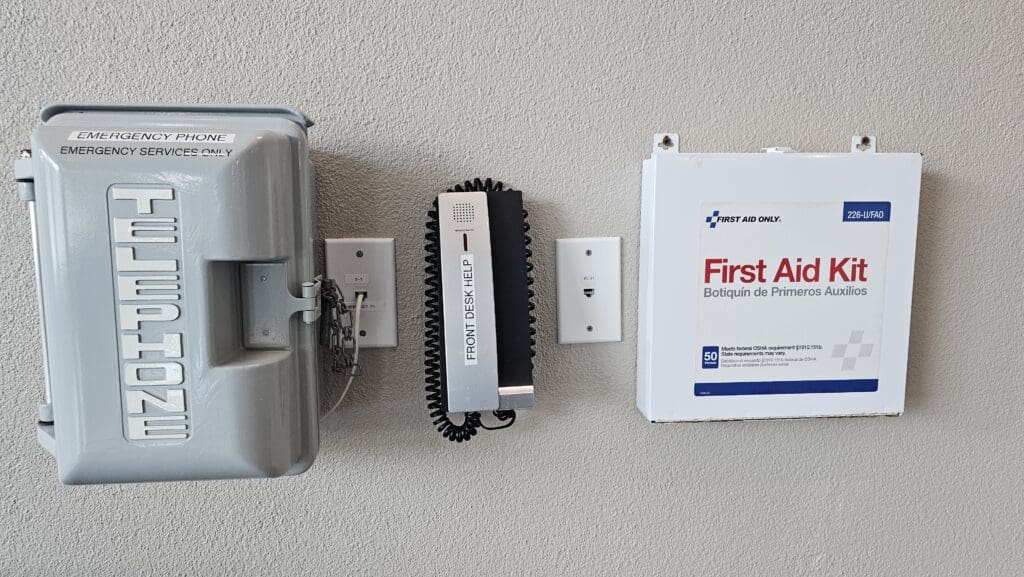 a telephone and first aid box on a wall