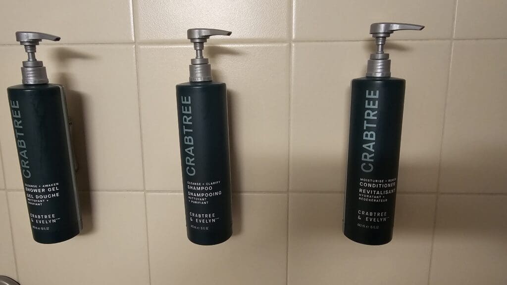 a couple of shampoo bottles on a tile wall