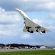 a jet flying over a runway