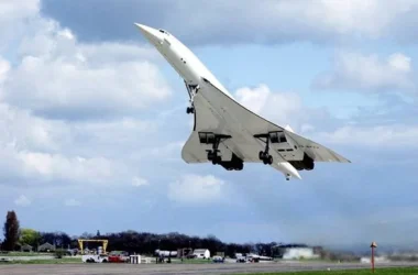 a jet flying over a runway