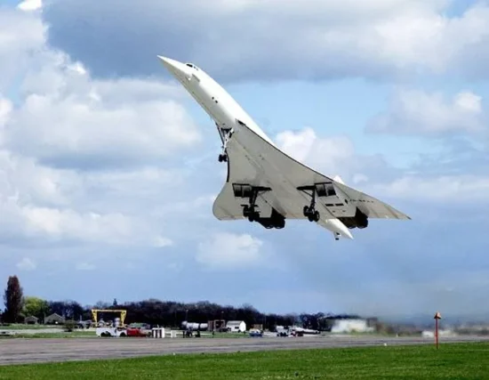 a jet flying over a runway