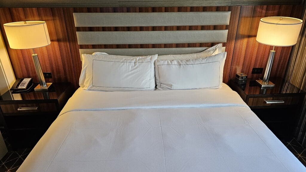 a bed with white sheets and pillows