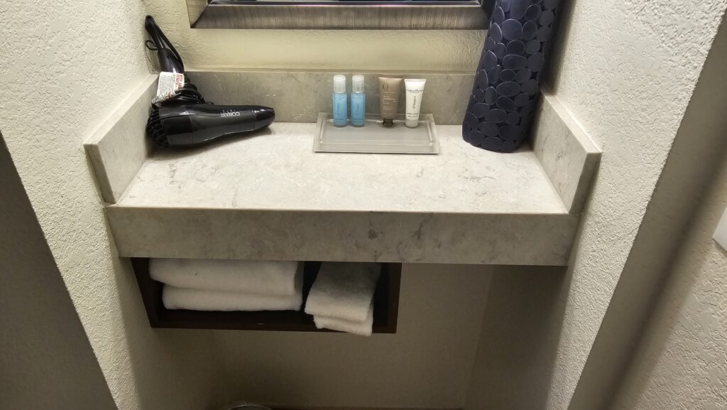 a shelf with a towel and a blow dryer