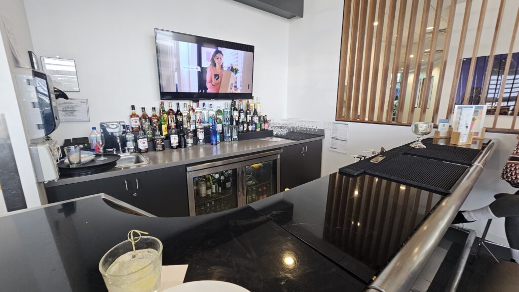a bar with a television and bottles on the wall