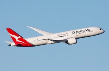 a white and red airplane flying in the sky