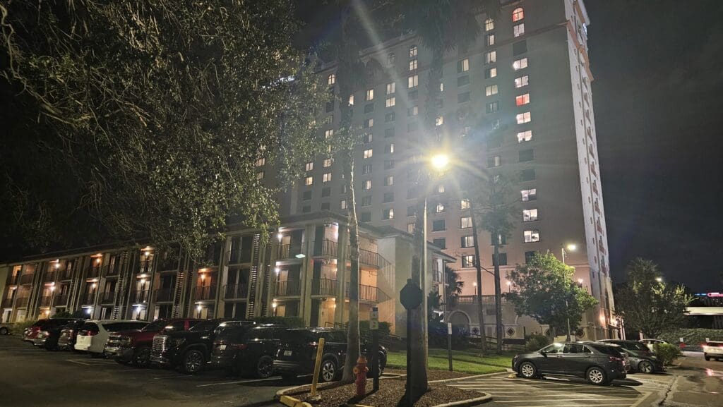 a parking lot with cars and buildings at night