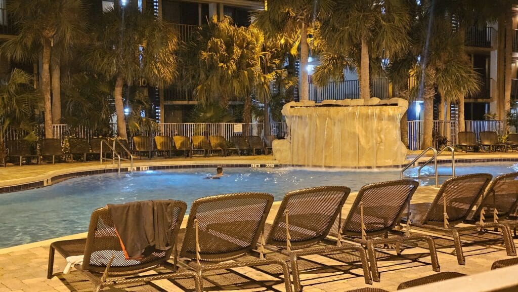 a pool with a waterfall and a man in it