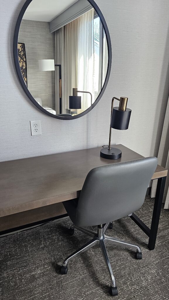 a desk with a chair and a mirror