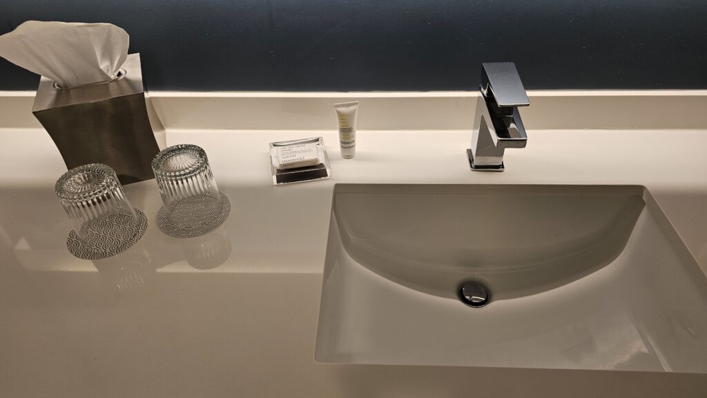 a sink with a faucet and a soap and a bottle