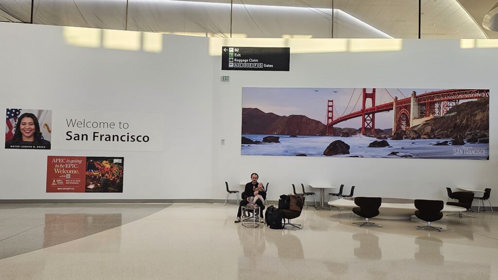 a man sitting in a chair in front of a large white wall