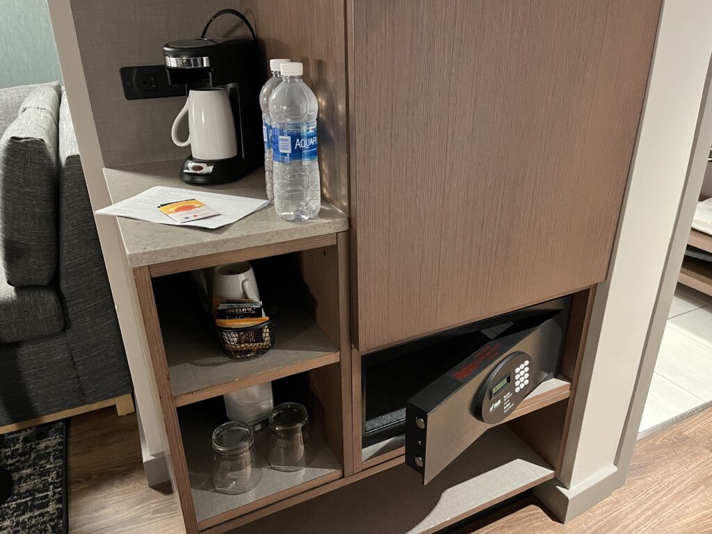 a shelf with a coffee maker and bottles on it