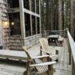 a wooden deck with chairs and a table in the woods