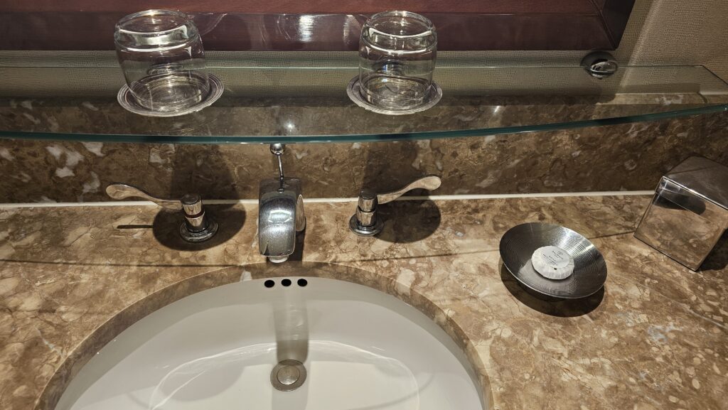 a sink with a glass shelf above it