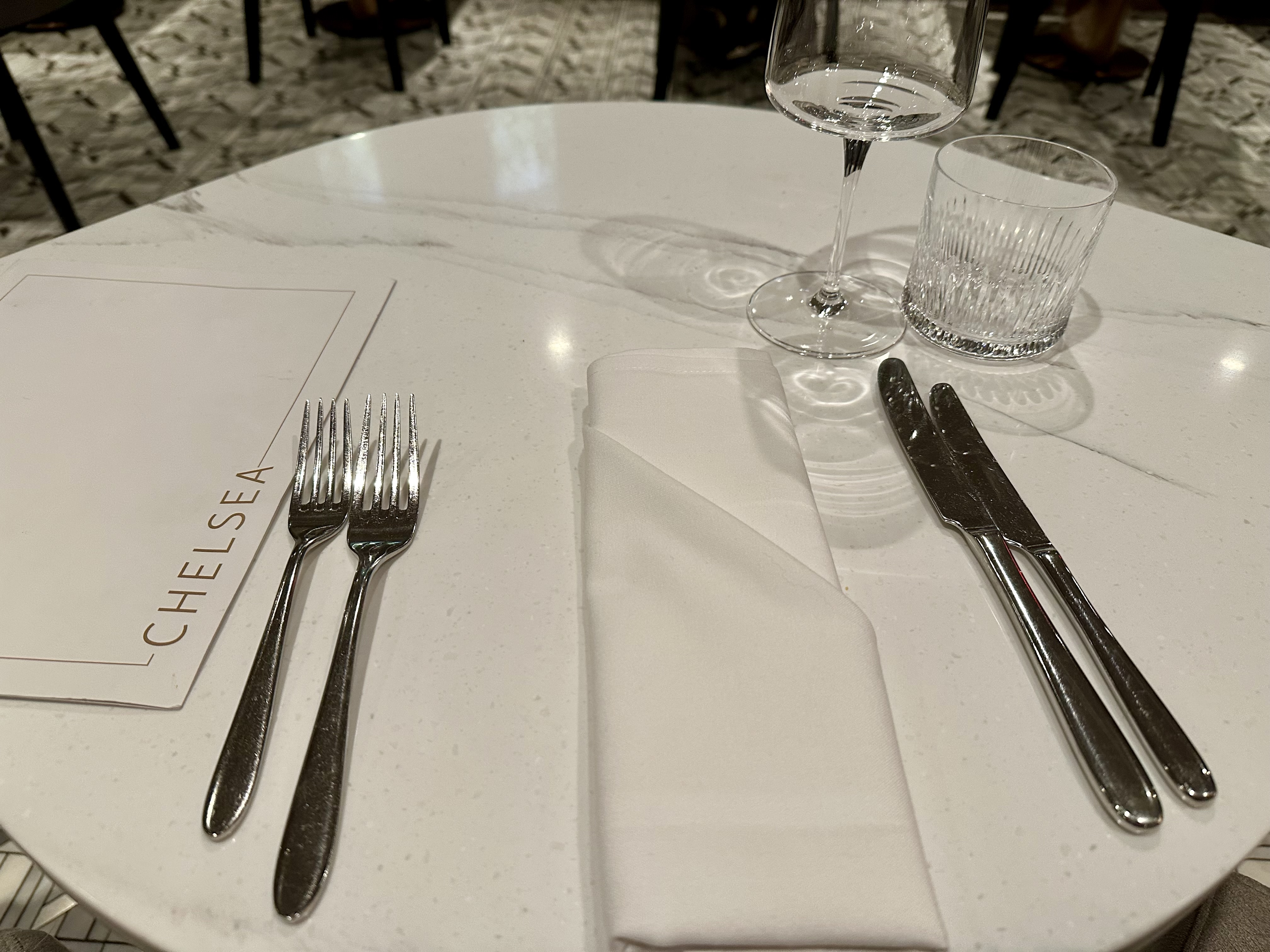 a table with a glass and silverware