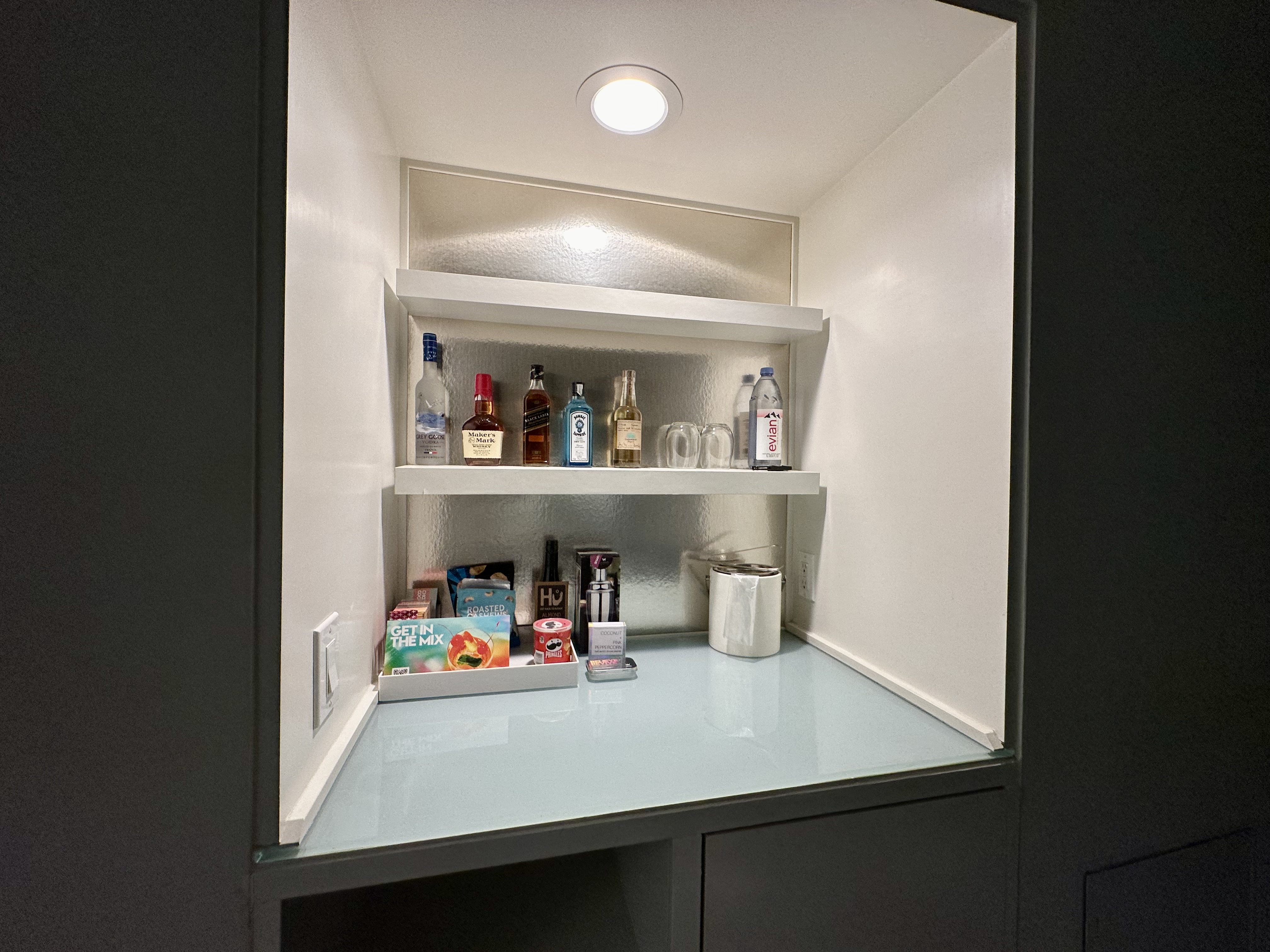 a shelf with bottles and other items inside a cabinet