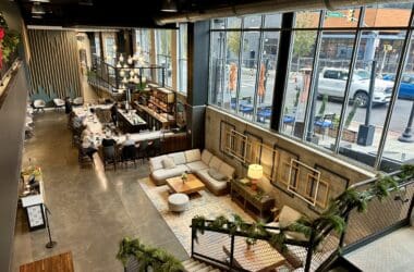 a room with a large window and tables and chairs