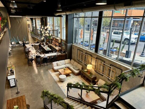 a room with a large window and tables and chairs