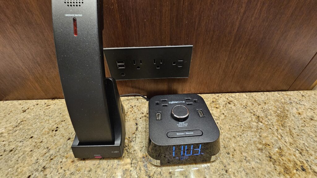 a black alarm clock next to a black speaker