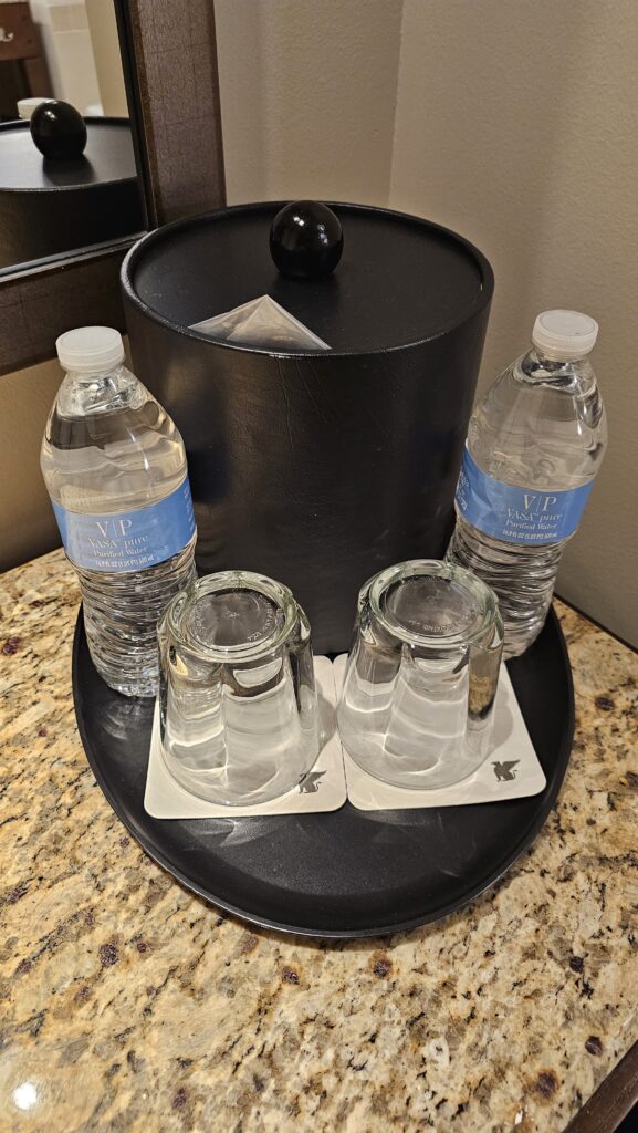 a group of water bottles and glasses on a black container