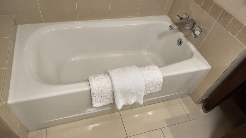 a bathtub with towels on the side