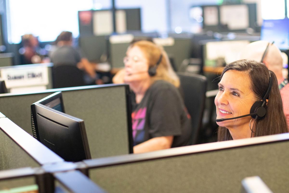 a woman wearing a headset and smiling at the camera