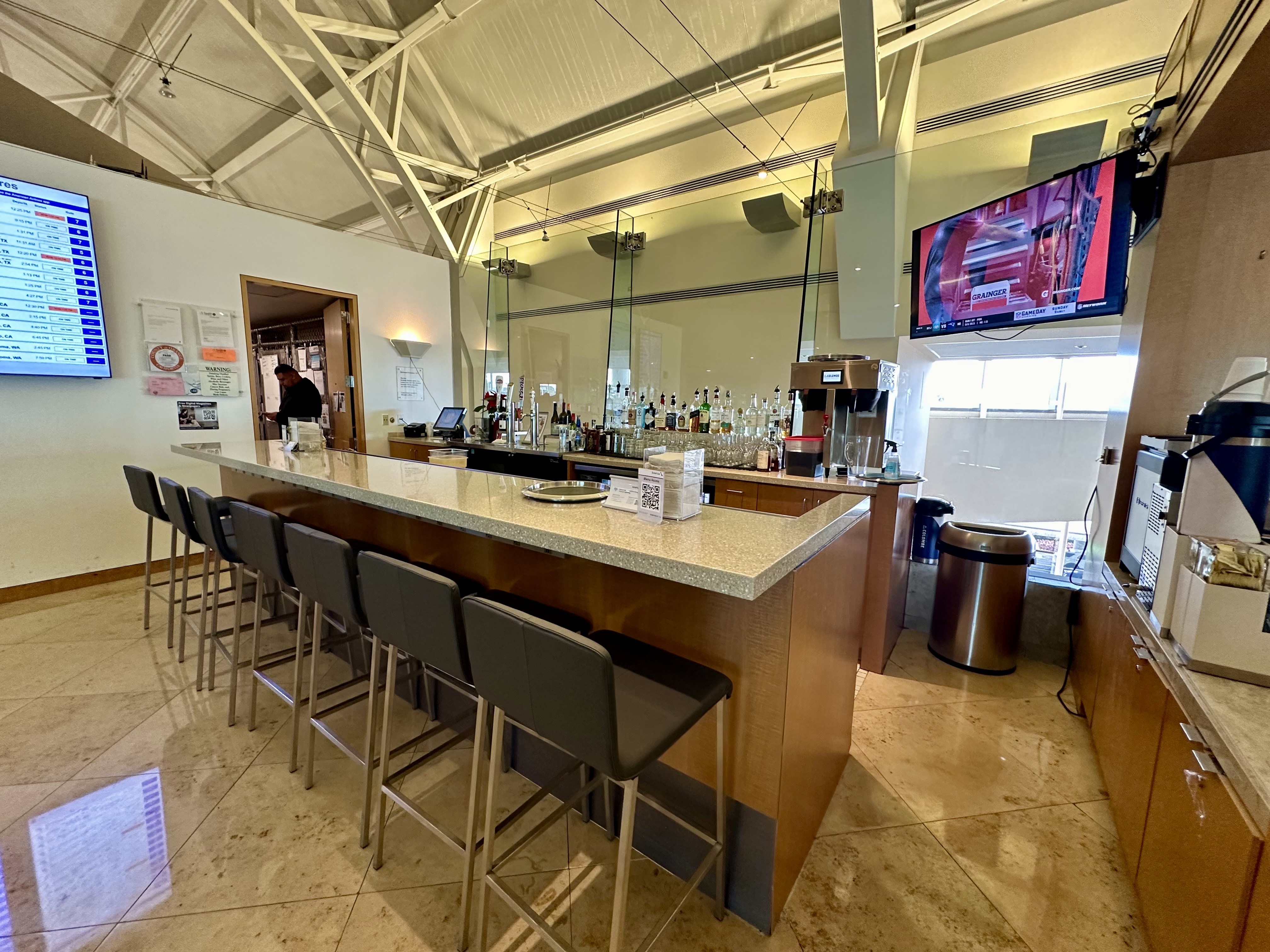 a bar with a counter and chairs at the Admirals Club Orange County