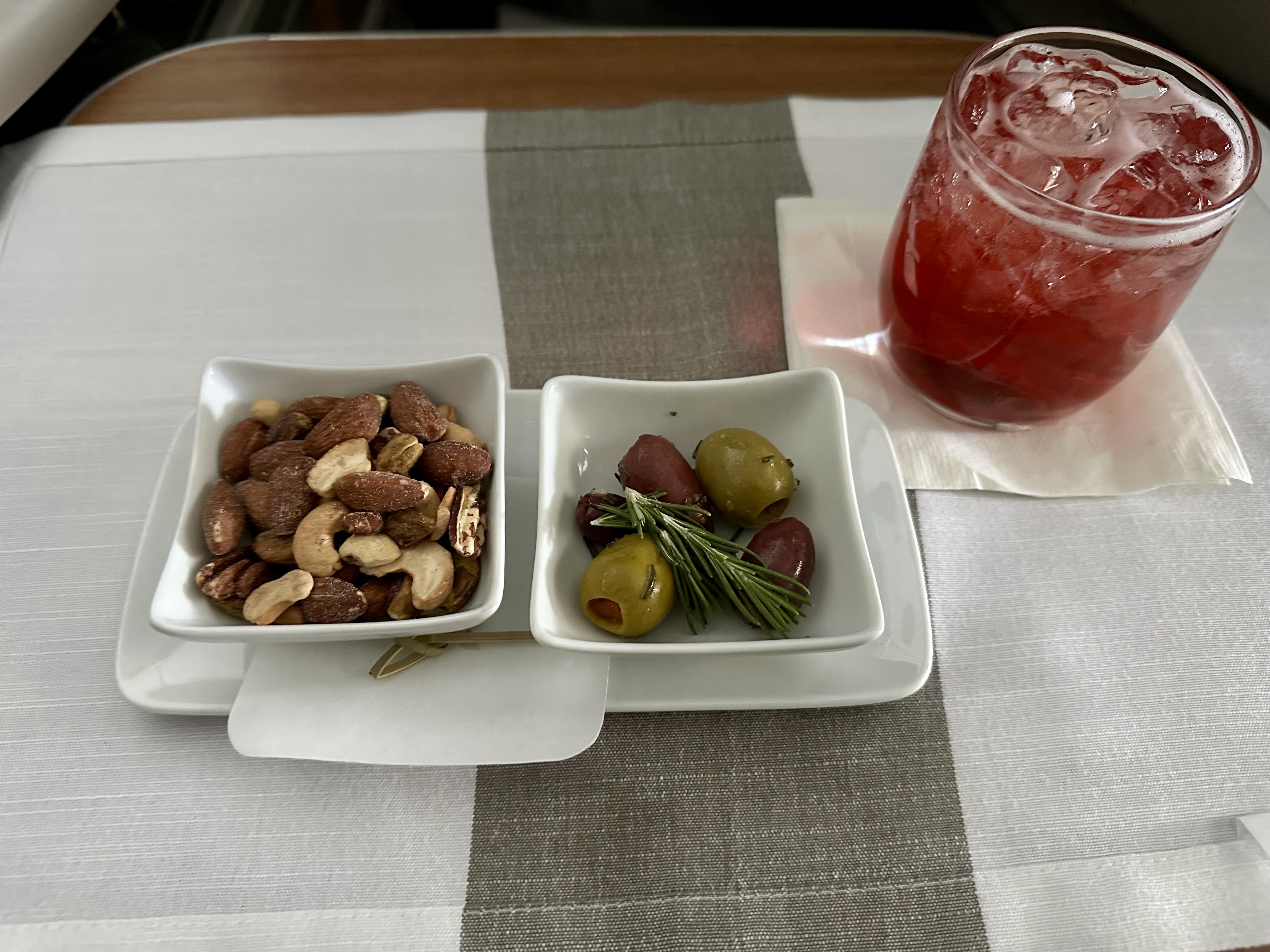 a plate of nuts and olives on a table