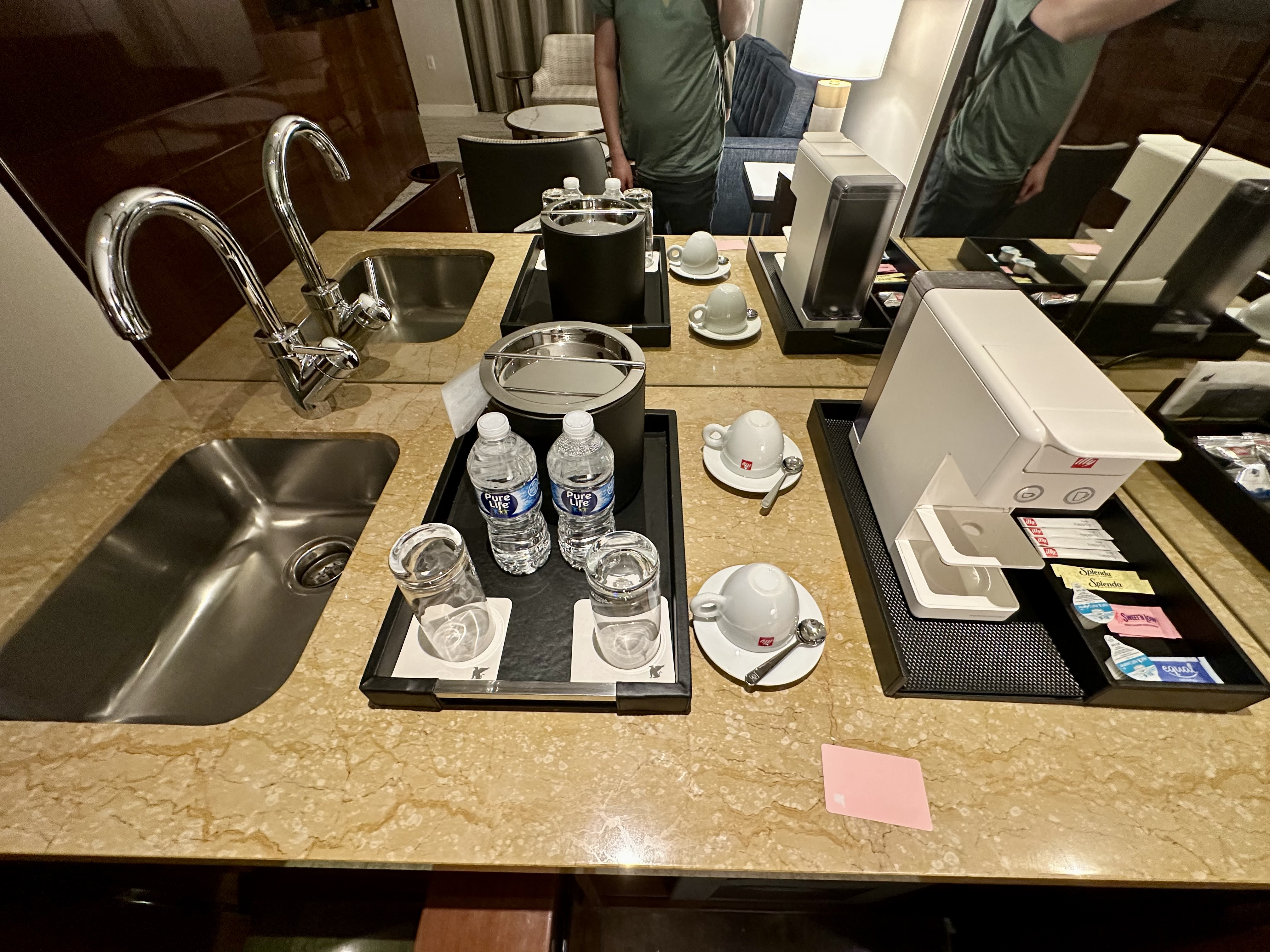 a counter top with a tray of water bottles and cups
