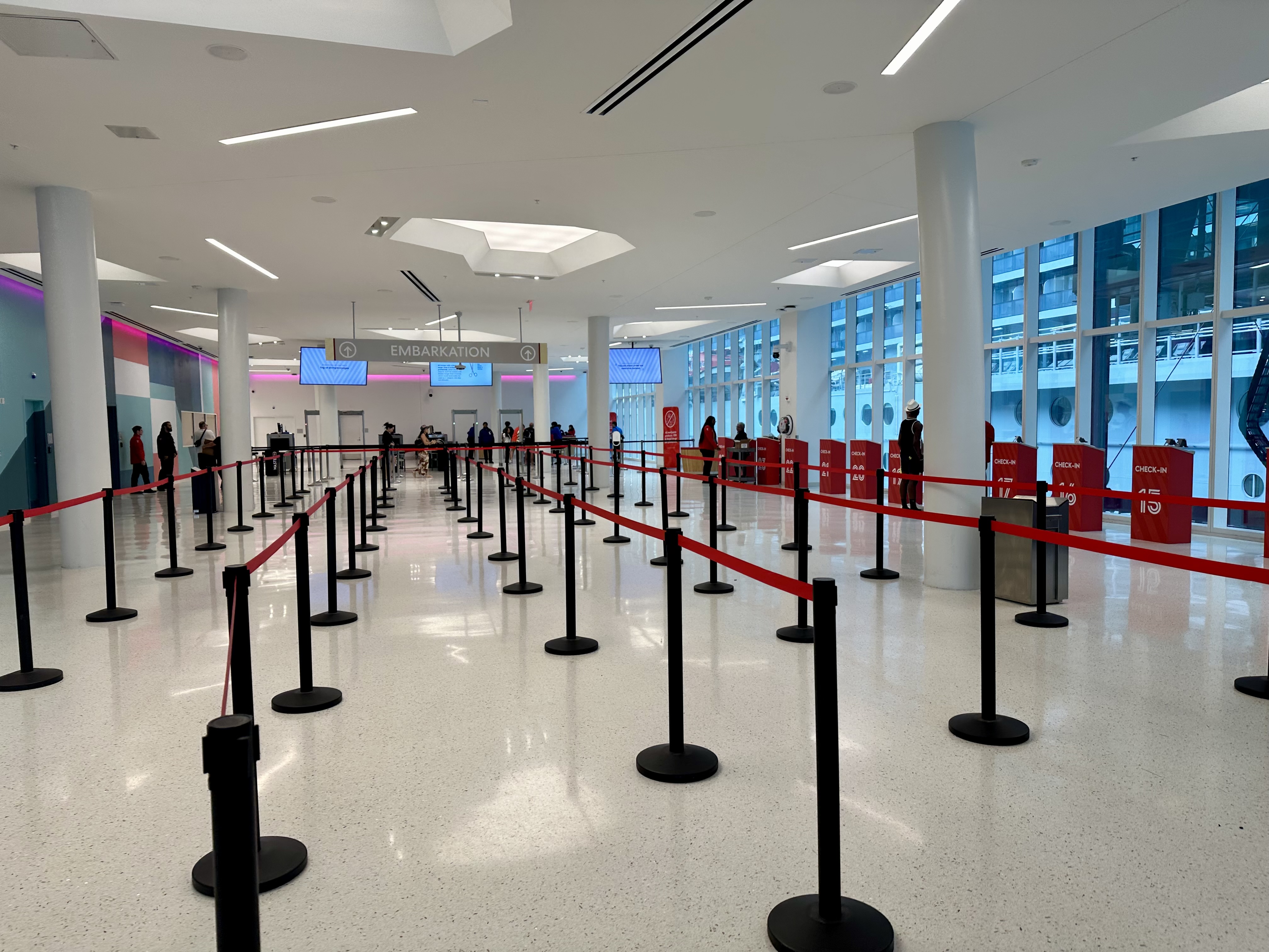 a line of people in a building for Virgin Voyages Embarkation