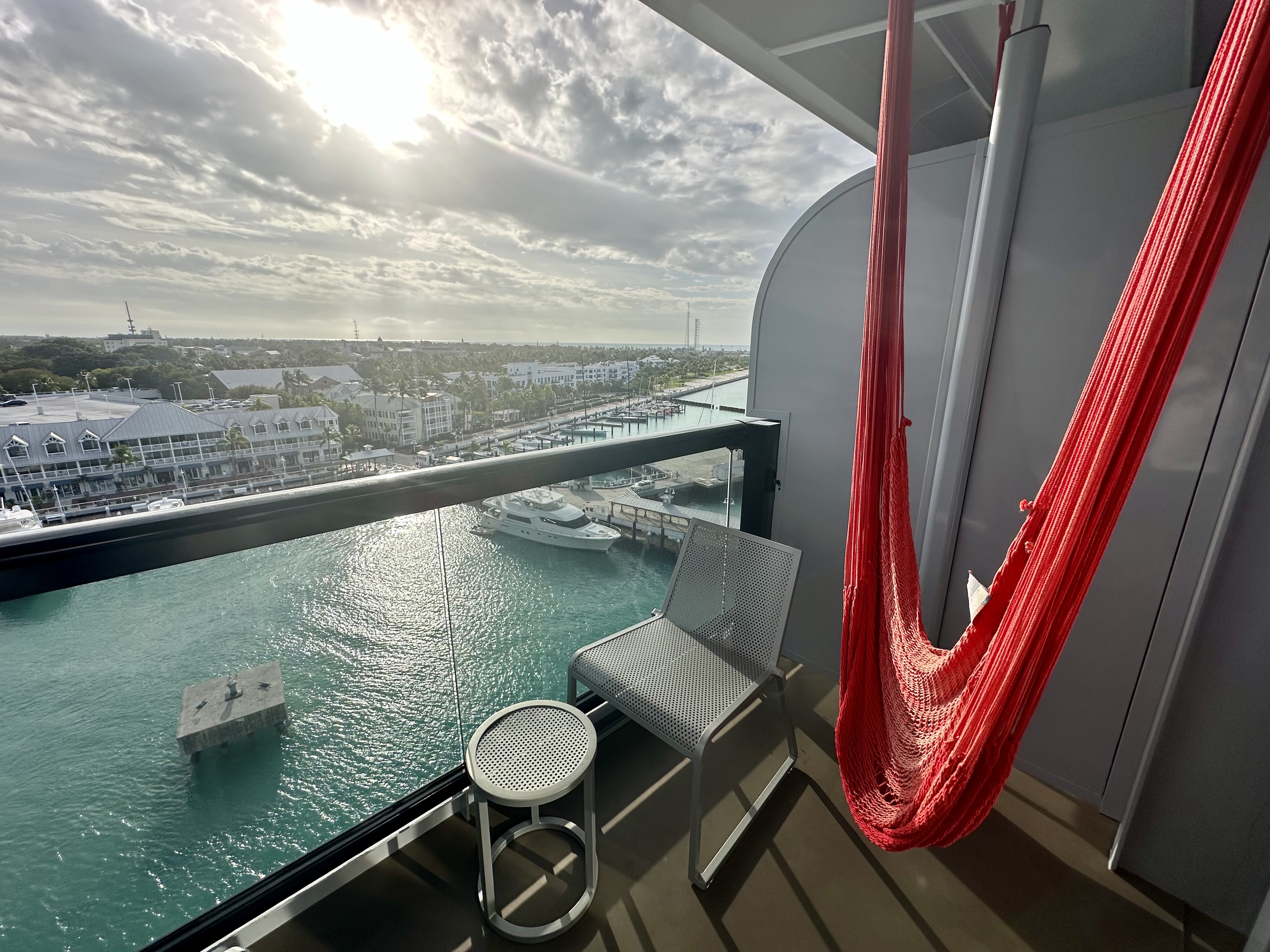 a hammock on a balcony overlooking a body of water on a Virgin Voyages Sea Terrace Cabin