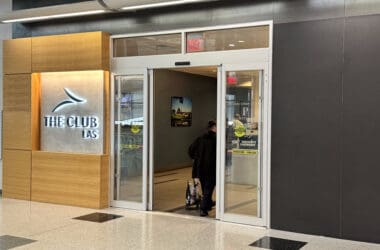 a person entering a building with a luggage bag
