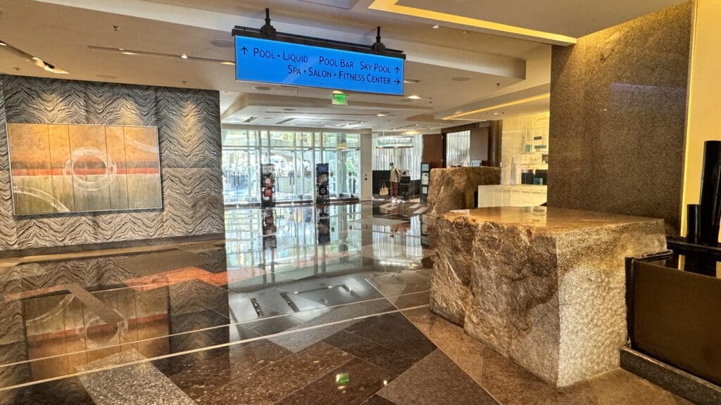 a lobby with a sign and a stone wall