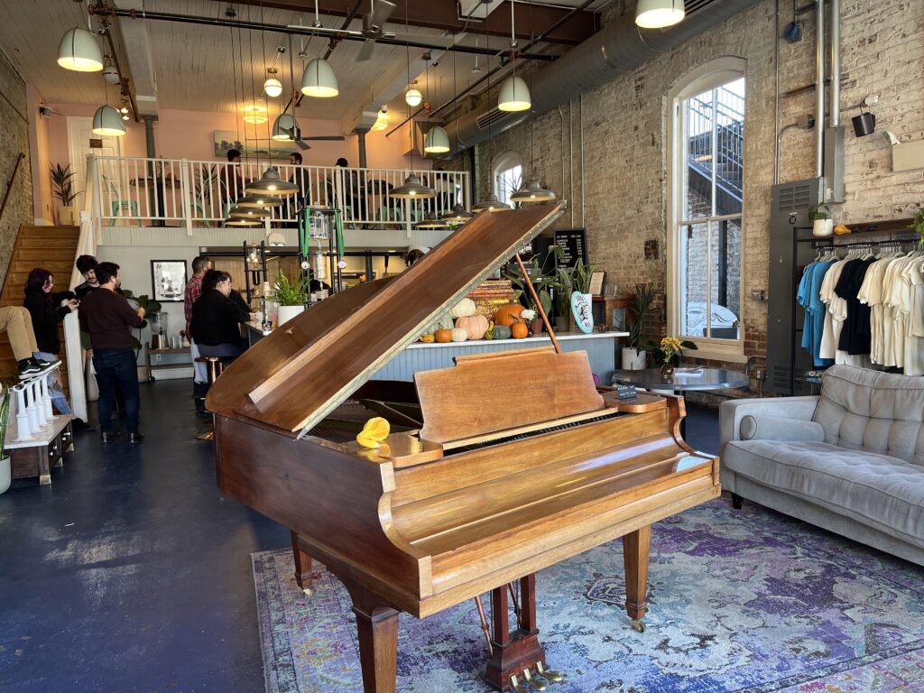 a piano in a room with people and a balcony