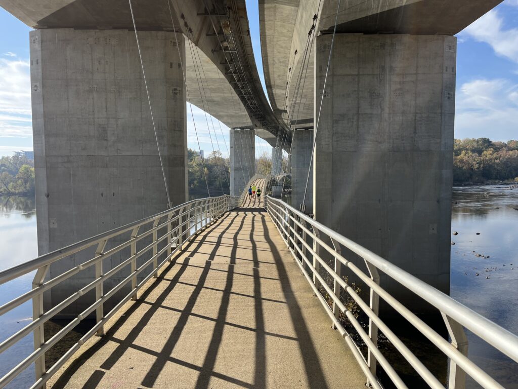 a bridge with a railing and people walking on it