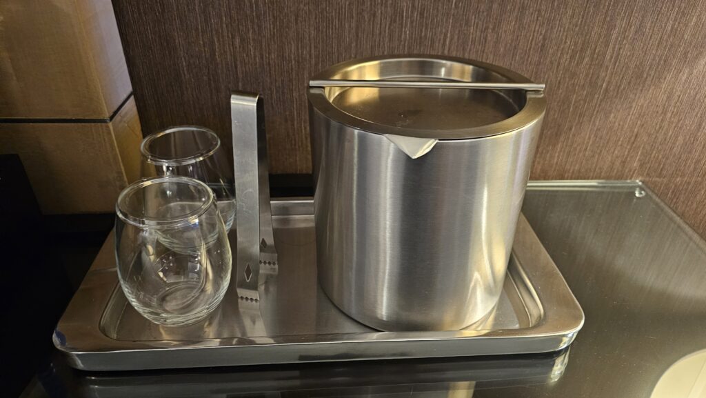 a metal bucket and glasses on a tray