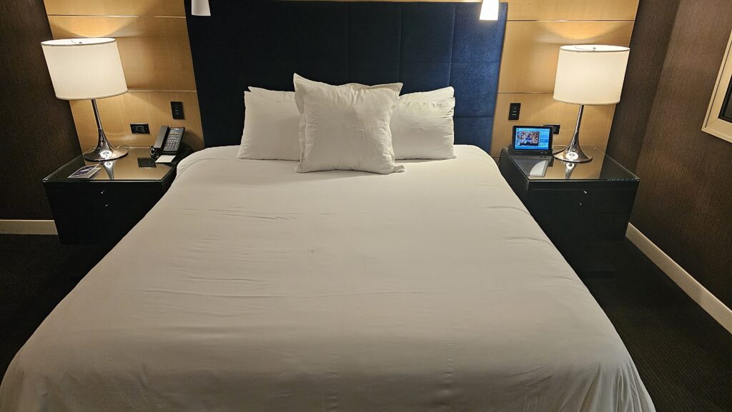 a bed with white sheets and a blue headboard