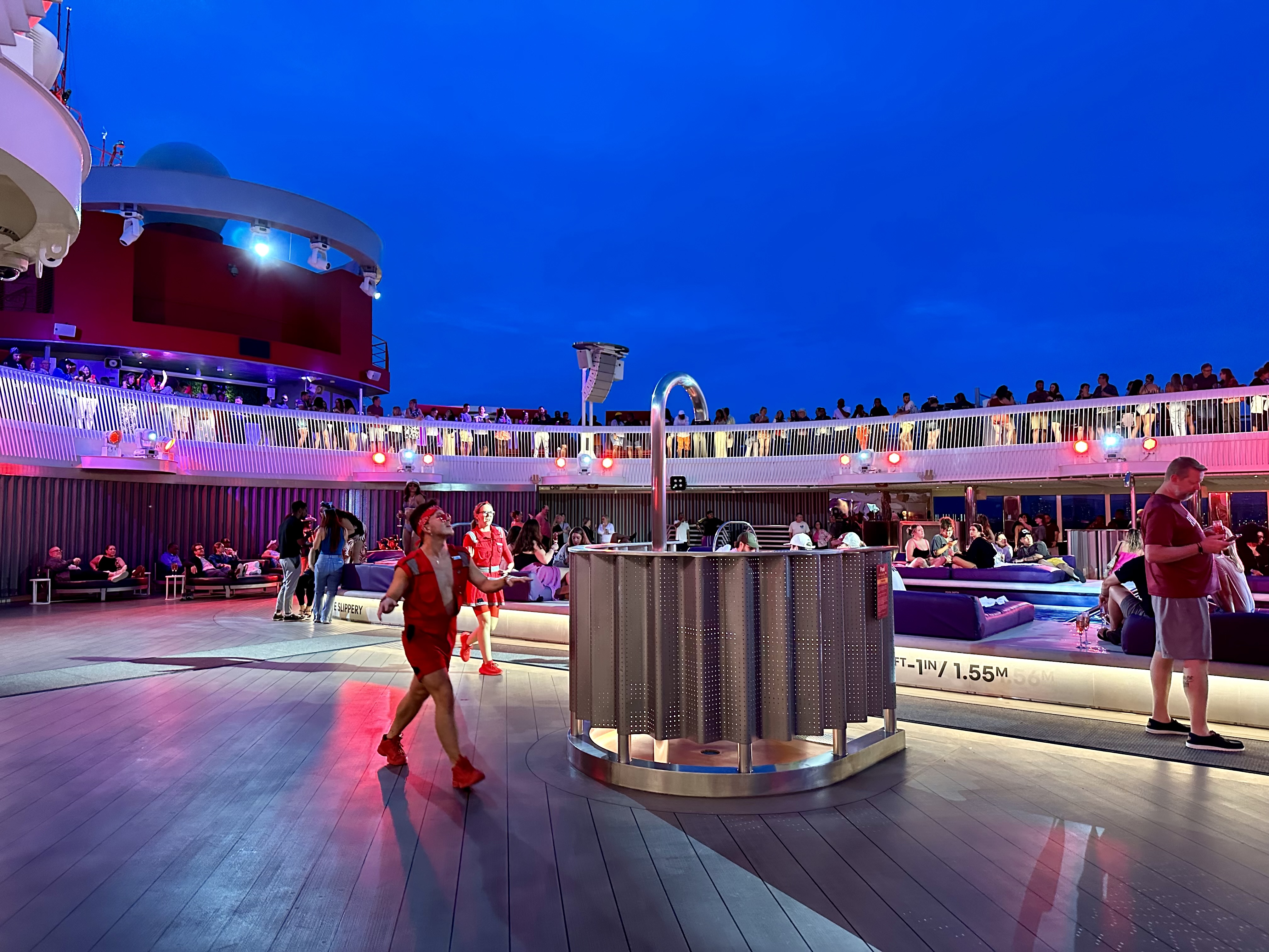 a group of people on a deck on Virgin Voyages Scarlet Lady