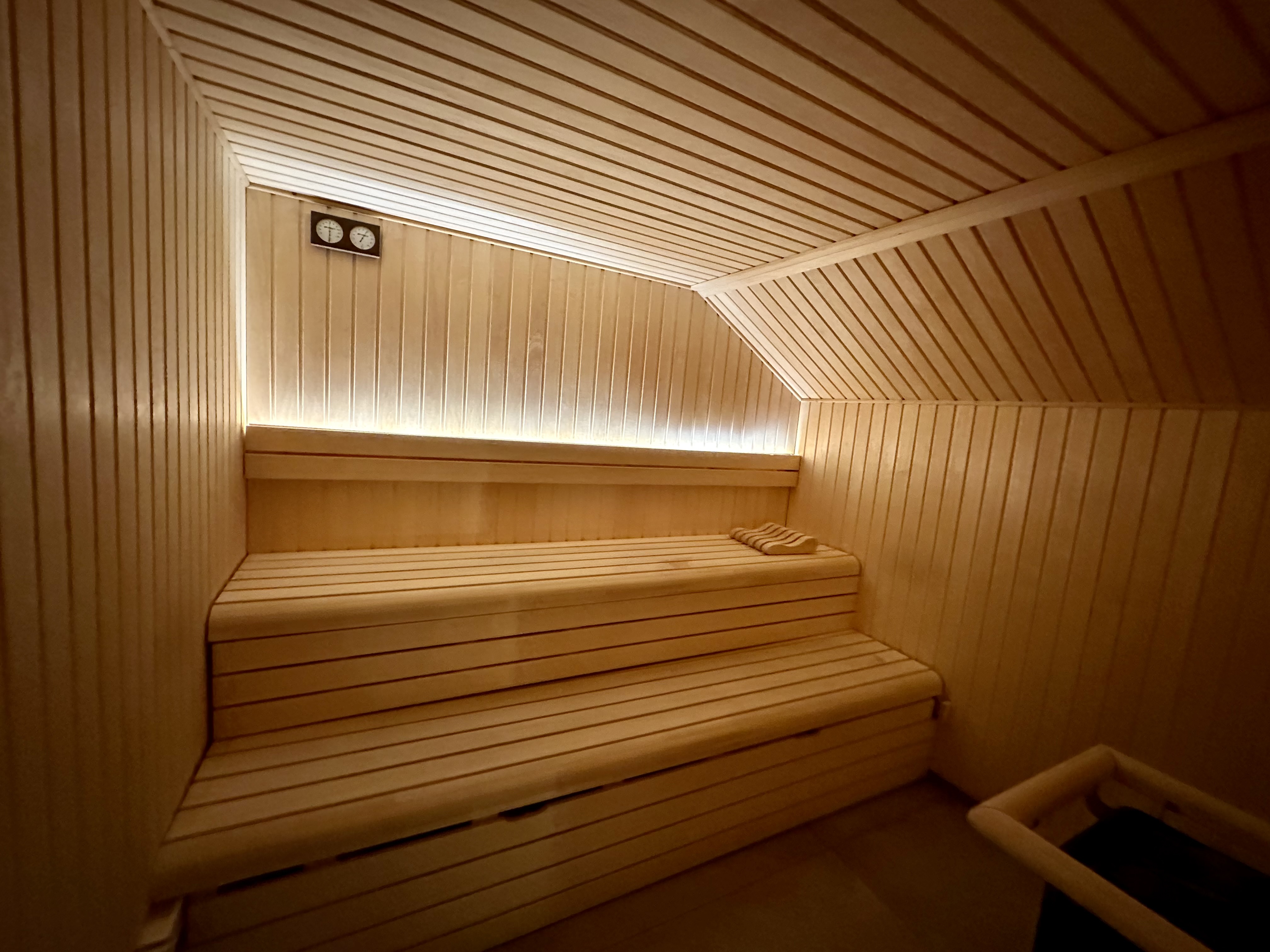 a sauna with wooden benches and a light in the ceiling