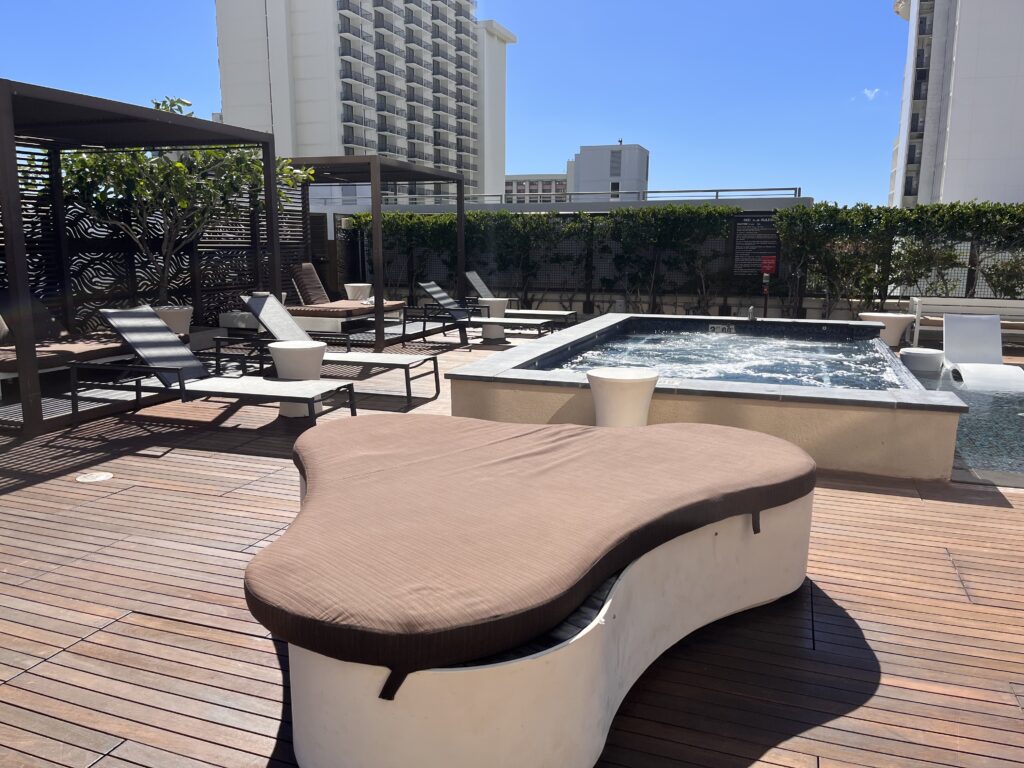 a pool with a hot tub and a bench on a rooftop