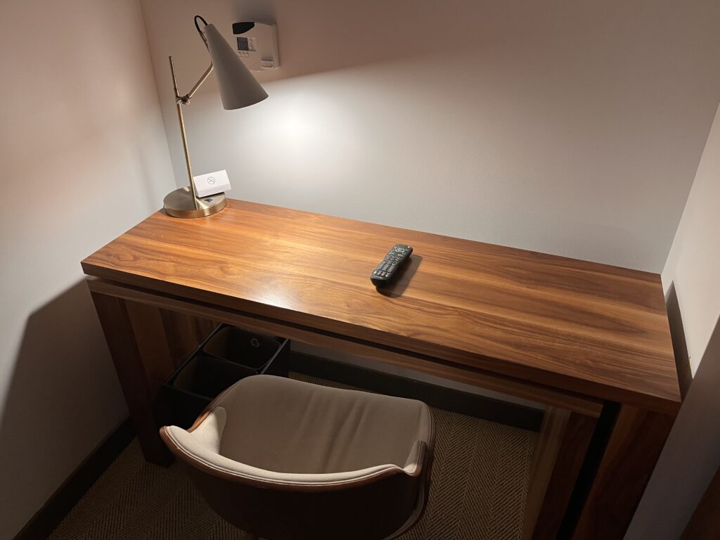 a desk with a remote control and a lamp