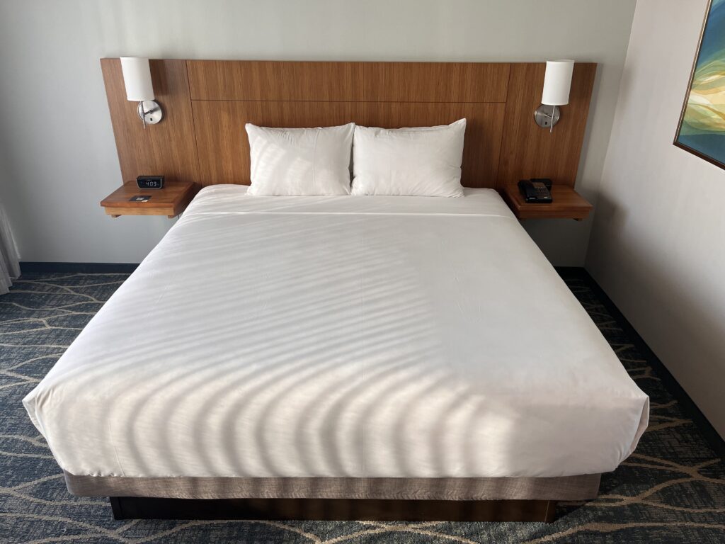 a bed with white sheets and pillows