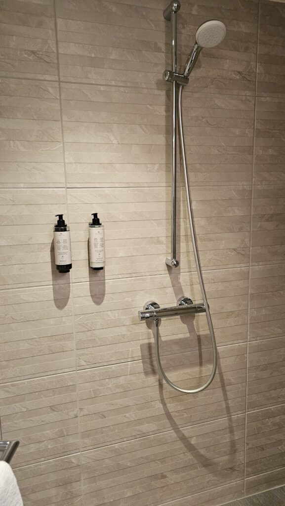 a shower head and soap dispensers on a wall