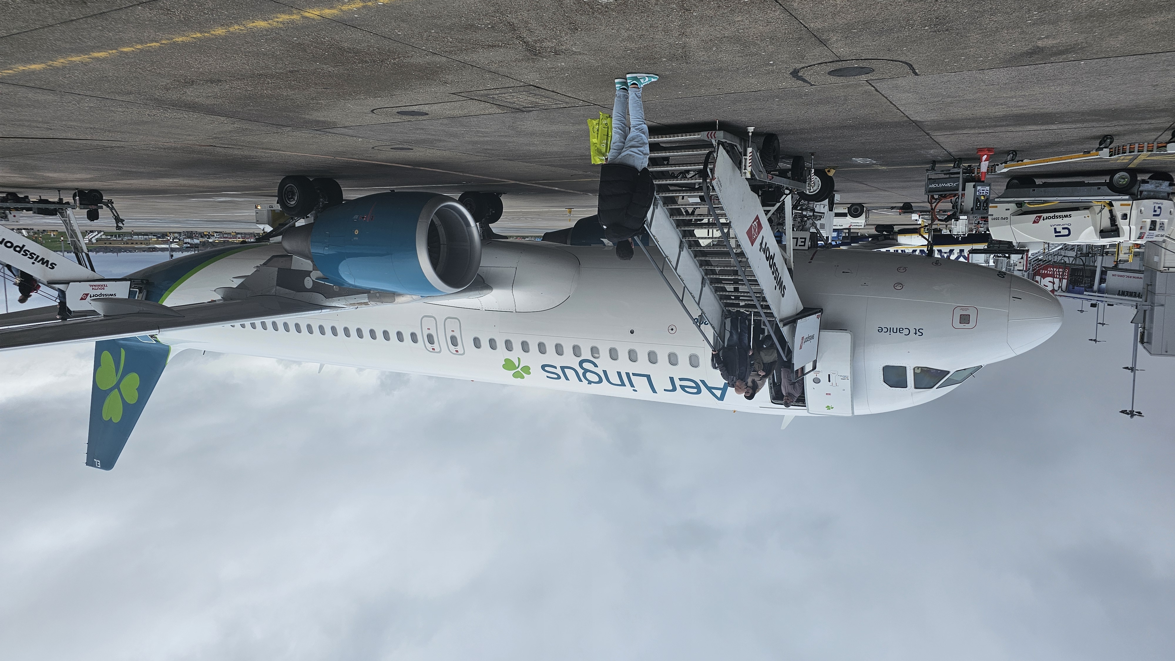 a plane with people boarding stairs