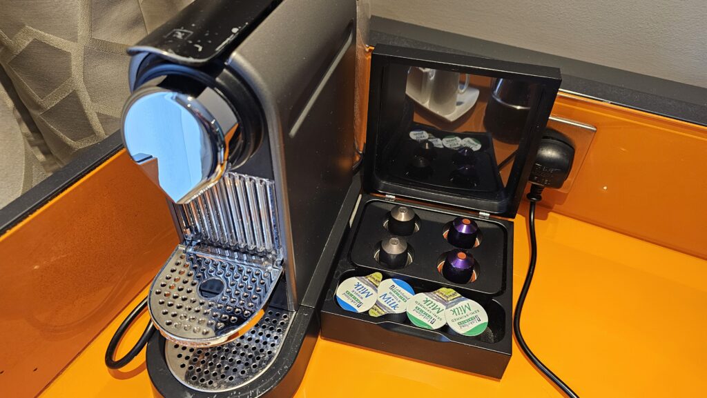 a machine with a case of coffee capsules