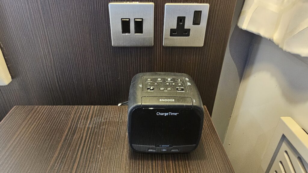 a black alarm clock on a wood surface