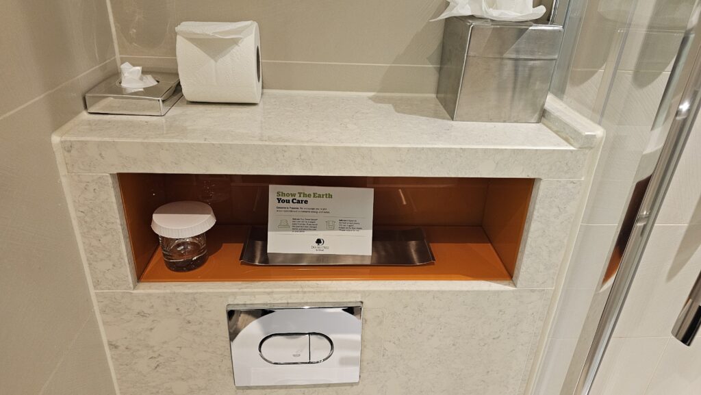 a shelf with a box of tissues and a sign on it